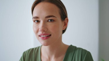 Ofis portresindeki kameraya bakan pozitif iş kadını. Ofiste çalışan genç kadın yönetici pozu. Çekici kız yönetici iş yerinde dinleniyor. Güzel bayan profesyonel evde yalnız..