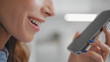 Menajer dudakları, akıllı telefonların yakın çekimini konuşuyor. Gülümseyen kadın cep telefonunu elinde tutuyor. Tanınmayan güzel kız sesli mesaj kaydediyor. İş kadını iş müşterisiyle konuşuyor.