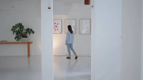 stock image Gallery visitor looking paintings on weekend. Woman walking contemporary museum enjoying modern art. Unrecognized thoughtful brunette inspecting exposition collection. Inspiration exhibition concept.