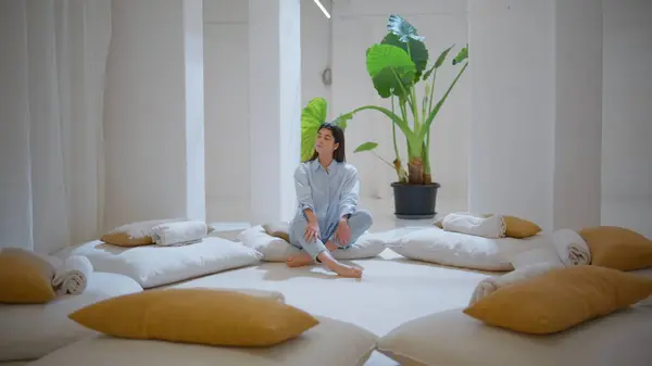 stock image Dreamy woman relaxing alone in cozy yoga space. Peaceful manager rest after work contemplating in comfy therapy room. Beautiful serene girl enjoying tranquil moment feeling inner harmony peace of mind