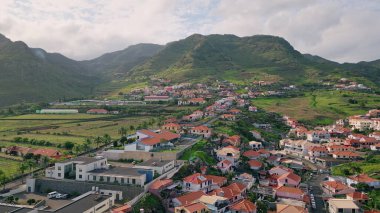 Drone yaz köyünün çatıları gün ışığında. Yeşil dağlardaki güzel sakin Akdeniz binaları. Sakin sahil kasabasının havadan görünüşü. Adadaki huzurlu kırmızı evler. Rahatlatıcı seyahat hedefi.