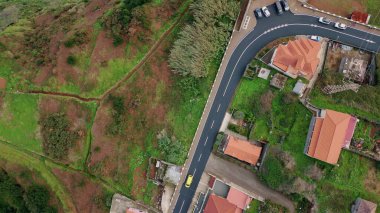 Samimi evler arasında uzanan köy yolu huzur verici bir manzara yaratıyor. Kırsal araziyi kaplayan yemyeşil bir arazi. Güzel caddelerde gezinen arabalar. Havadan çekilen kırmızı binaların çatıları