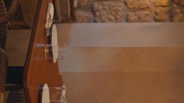 Samimi, orjinal lambaların altında restoran masaları servis ediyordu. Akşamları dikey olarak dekore edilmiş güzel bir kafe. Ahşap masalarda duran buketlerle süslü sofra takımı..