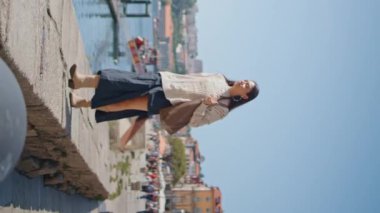 Nehirde gezen kız çantasıyla tek başına geziyor. Güzel bir turist kadın, bahar şehrini dikey bir şekilde keşfe çıkıyor. Rahatlamış kadın hafta sonu tek başına gezinin tadını çıkarıyor.. 