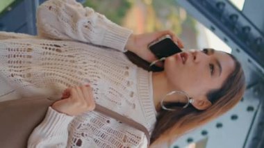 Nehir köprüsünde cep telefonuyla konuşan Latin bir kadın var. Sakin ve ciddi bir kız cep telefonuyla konuşuyor. Demir inşaat alanında dikey olarak yürüyor. Esmer model akıllı telefon konuşması yapıyor.