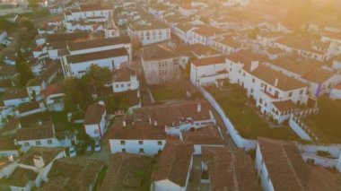 Gün batımında güzel banliyö binaları altın ışık drone manzaralı. Kırmızı kiremitli çatılar. Geleneksel tarihi şehir evleri. Akşam güneşinde. Resimli şehir manzarası rahat sokaklar yerleşim yerleri