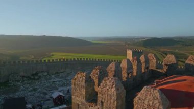 Yeşil vadi kırsal kesim insansız hava aracı manzaralı kale duvarları. Canlı güneşli alanlara yerleştirilmiş taştan antik tahkimatı olan manzara. Ortaçağ mimarisi kırsal çevrede doğa üzerine.