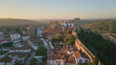 Güzel yeşil kırsal hava manzaralı antik şatosu olan bir turizm şehri. Kırmızı kiremitli çatıları olan eski caddeler boyunca uzanan taştan ortaçağ duvarları. Akşam ışığında resimli şehir manzarası.