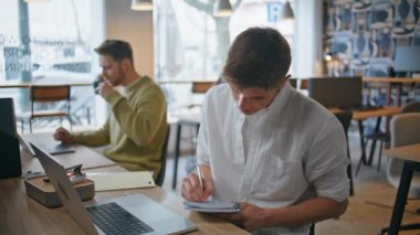 Not defterine notlar alan odaklanmış bir işçi ofiste tek başına oturuyor. Ciddi derecede zeki bir adam düşüncelerini kapalı alanlara yazıyor. Kendine güveni tam bir işadamı açık alanda kağıt not defteri tutuyor.