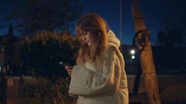 Gece vakti aydınlık şehir parkında akıllı telefon kullanan genç bir kadın. Ciddi bir esmer sokak lambalarının altında cep telefonuyla yazı yazıyor. Endişeli kız bekliyor. Akşamın geç saatlerinde telefonla toplantı..