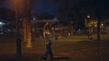 Gece parkında tek başına yürüyen bir kadın akıllı telefon mesajlarına odaklanmış. Aydınlatılmış sokak lambaları altında cep telefonunda yazan şık esmer. Rahat kız cep telefonuyla karanlık şehirde geziniyor..