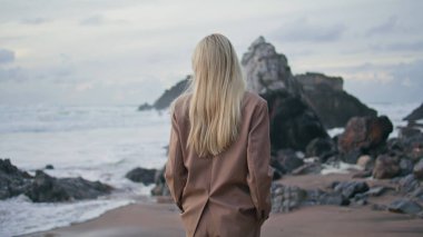 Akşamları okyanus dalgalarını düşünen sakin bir kız. Çekici bir model kamerayı çıplak göğsü olan şık bir takım elbiseyle döndürüyor. Güzel sarışın kadın gün batımında huzurlu bir hafta sonunun tadını çıkarıyor..