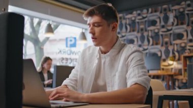 Ofis çalışanı laptop açmaya modern masa kapanışında başladı. Sakin bir yönetici, bilgisayar başında çalışıyor ve iş yerinde mola veriyor. Yaratıcı tasarımcı görünümlü ekran açık uzay odasından esinlenildiğini hissediyor 