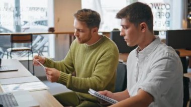 Başlangıç takımı ofisteki bilgisayarı çevrimiçi arıyor. Bilgisayar ekranına dokümanları gösteren yaratıcı iş adamları. İki erkek arkadaş modern odada görüntülü konferans görüntülerini izliyorlar. 