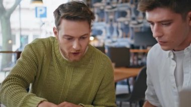 Yakın plan odaklı tasarımcıların beyin fırtınası ofisi. Yaratıcı iki adam ciddi iş arkadaşları iş yerinde tartışan notlara bakıyor. Modern ajans kabinesinde takım olarak konuşuyoruz. Meslek kavramı