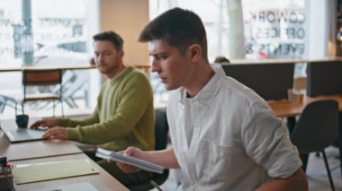 Bilgisayarlarda çalışan ortak çalışan insanlar yakın çekimde. İş yerinde iş arkadaşına soran bir adam. Gülümseyen iş adamları ofiste dizüstü bilgisayar izlemeyi tartışıyor. Kabinedeki projeyi inceleyen kendine güvenen ekip
