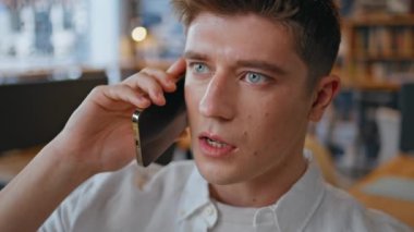 Ofiste konuşan rahat iş arkadaşı akıllı telefon konuşması. Yaratıcı iş yerinde cep telefonuyla iletişim kuran ciddi bir adam. Genç işadamı şirket kabinesinde iş hakkında konuşuyor. 