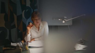 Geç saate kadar çalışan ofis çalışanı. Gece mesaisi. Yakın plan. Dizüstü bilgisayardaki belgeleri okumaktan yorulmuş bir iş kadını. Tükenmiş profesyonel kız menajer gece dolabında kontrat arıyor. 