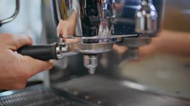 Barista 'nın elleri kahve makinesini yerleştirirken nefis kahve çekimleri yapıyor. Bilinmeyen garson espresso öğütücü kullanıyor aromatik içecek hazırlıyor. Kafedeki özel sistemi kullanan profesyonel bir işçi.