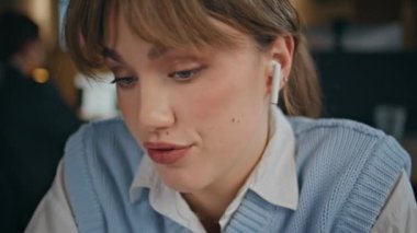 Kulaklıklı kadın antrenör web sitesinden konuşuyor. Laptop kamerasına yakın çekim. Pozitif genç iş kadını video konferansında ofis masasında konuşuyor. Çevrimiçi sohbette kendine güvenen yönetici iş sunar 