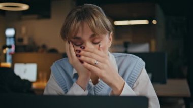 Yorgun bir ofis çalışanı, gece geç saatlerde ofiste çok çalışıyor. Dizüstü bilgisayarda çalışan bunalmış iş kadını motivasyonsuz hissediyor. Profesyonel kız müdür gece bilgisayar ekranına bakıyor 