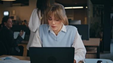 Ofisin içindeki modern dizüstü bilgisayarda daktilo eden ciddi bir kız yöneticisi. Gömlekli çekici genç iş kadını bilgisayar ekranı görünümlü oturma masası. Odaklanmış kadın şirket çalışanı internette sörf yapıyor. 