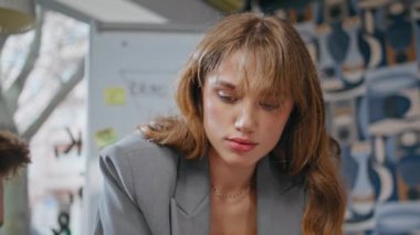 Konferans odasında bayan yönetici konuşuyor. Yakın plan. Genç iş adamları toplantı odasında fikir alışverişinde bulunuyor. Kadın patron, erkeklerle iletişim stratejisini açıklıyor. Şirket yaşam tarzı 