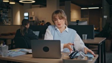 Ofisin iç kısımlarında modern dizüstü bilgisayarda daktilo kullanan odaklanmış bir iş kadını. Çekici genç kız yönetici gömlekli bilgisayar ekranlı oturma masası görünümlü. İnternette sörf yapan ciddi kadın şirket çalışanı. 