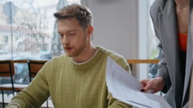 İki iş arkadaşı büyük pencerelerde fikir alışverişinde bulunuyor. Sakallı tasarımcı, tanınmayan bayan yöneticinin modern işyerindeki açılışı tartıştığını söylüyor. Yaratıcı ajansta iletişim kuran meslektaşlar.