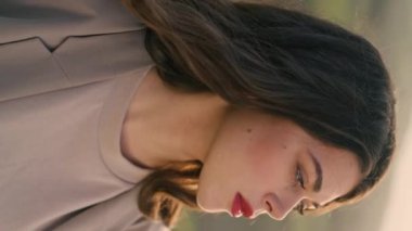 Doğada sonbahar günü poz veren baştan çıkarıcı güzel modelin portresi. Kırmızı dudaklı genç kadın, tek başına vadi yeşilinde dikey duran kameraya bakıyor. Kız manzaranın tadını çıkarıyor