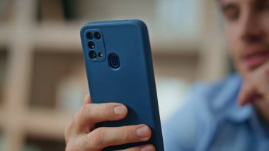 Sabah apartmanında cep telefonuyla oynayan gülümseyen adam. Mutlu yakışıklı işadamı iş yerinde cep telefonundan mesaj alıyor. Neşeli serbest çalışan adam sosyal medyada haberlere bakıyor.