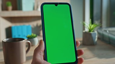 Tanımlanamayan iş adamı cep telefonundan mesaj okuyor şirket masasında oturuyor. Adam elleri yeşil ekran akıllı telefonuna dokunuyor. Şirket yöneticisi Chroma Key cep telefonunda internette sörf yapıyor