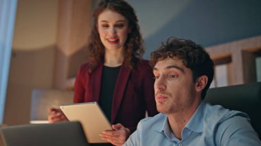 Ofiste iş birliği yapan iki meslektaşım yakın çekim yapıyor. Ciddi bir iş adamı akşam toplantısında gülümseyen kadın danışmanla iş akışını tartışıyor. Erkek yöneticiye tablet verilerini gösteren pozitif iş kadını.