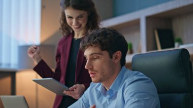 İş arkadaşlarının bilgisayarları iş projelerini internette sunar. Kapatın. İki meslektaş uzaktan iş görüşmesi yapıyor ve iş tartışıyorlar. Kadın sekreter, erkek yöneticiye tableti gösteriyor.