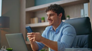 Gülümseyen CEO, atölyedeki akıllı telefondan mesaj atıyor. Çağdaş ofiste cep telefonu sörfü yapan yakın çekim adamı. Esmer adam iş molasında internet iletişiminin keyfini çıkarıyor. Dijital yaşam tarzı kavramı