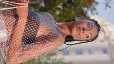 Moda Afrikalı bayan Summer Caddesinde dikey olarak bekleyen bir arkadaş. Şehir merkezinde cep telefonu kontrol eden mutlu esmer kadın. Arka planda cep telefonu tutan gülümseyen kadın.