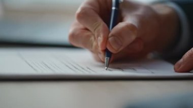 Yönetici el, ofis masasında yakın çekimle belge imzalıyor. Bilinmeyen işadamı şirket işyerinde veri yazma formu dolduruyor. Profesyonel yönetici şirket işyerinde evrak işleriyle uğraşıyor.