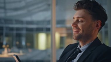 Olumlu patron, karanlık iş yerindeki akıllı telefondan mesaj yolluyor. Gülümseyen yakışıklı iş adamı mesai saatinden sonra cep telefonuna mesaj atıyor. Mutlu yönetici cep telefonundan mesaj okuyor.