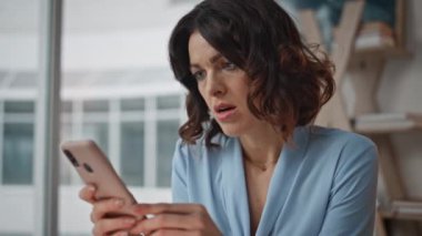 Şirket işyerindeki akıllı telefondan alınan krediyi okuyan girişimci şok oldu. Hayal kırıklığına uğramış kadın yönetici cep telefonu mesajını okuyor. Hoşnut olmayan iş kadını iş e-postası hakkında endişeli.
