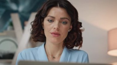 Ev çalışma alanında dizüstü bilgisayarla çalışan odaklanmış serbest çalışan birinin portresi. Modern ofiste bilgisayarını karıştıran ciddi profesyonel bir iş kadını. Çevrimiçi arama işine dahil olan çekici kadın çalışanlar.