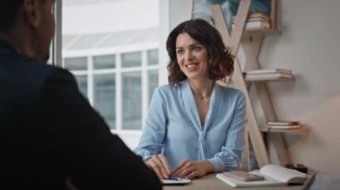 İş kadını, iş yerinde gülümseyen partnerini yakından selamlıyor. Profesyonel yöneticiler şirket toplantısında anlaşmayı tartışıyor. Dost canlısı kadın CEO iş adamıyla görüşmeler yapıyor..