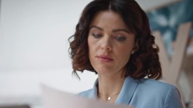 Şirket ofisindeki ciddi çalışan okuma belgelerini kapatın. Finans müdürü şirket işyerindeki evrak işlerine odaklandı. Kendine güvenen iş kadını istatistik raporunu analiz ediyor. Çalışma akışı konsepti