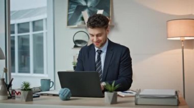 Ofis çalışanı, iş yerinde dizüstü bilgisayarda çalışırken kendini başarılı hissediyor. Gülümseyen işletme yöneticisi kurumsal çalışma alanında bilgisayar e-postalarında harika haberler okuyor. Mutlu çalışan kariyer terfisi.