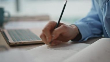 Ahşap masada el yazısı yazan bir kadın var. Bilinmeyen kadın serbest yazar dizüstü bilgisayarda kalem kullanarak notlar alıyor. Çevrimiçi iş sırasında önemli bilgileri belgeleyen ofis çalışanı
