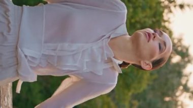Şehvetli kız yaz akşamında doğada esen rüzgardan hoşlanıyor. Havalı beyaz gömlekli baştan çıkarıcı kadın taş parmaklıklara yaslanmış dikey şarap kadehi videosuyla. Yeşillik ağaçlarında poz veren zarif bir model..
