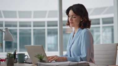 Modern ofis kapanışında yaratıcı yönetici planlama projesi. Kendine güvenen iş kadını laptopta çalışan ve verimli hisseden belgeleri okuyor. Kadın yönetici iş yerindeki iş raporlarını kontrol ediyor.