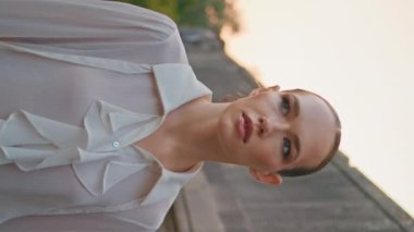 Sakin bir kadın, yaz akşamları ortaçağ binasında geziniyor. Kapatın. Antik mimaride dikey yürüyen rahat çekici bir kız. Beyaz gömlekli güzel bayan eski kaleyi keşfediyor..