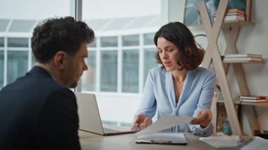 Modern ofiste sözleşmeyi tartışan iki ortak. Güvenilir iş kadını, iş yerindeki iş adamlarına anlaşma detaylarını açıklıyor. İş yerindeki proje planını analiz eden şirket arkadaşları.