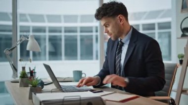 Laptop 'ta finansör daktilo raporuyla meşgul. Görev kapanışı üzerine odaklanmış. Ofisteki bilgisayar notları üzerinde çalışan ciddi bir iş adamı. İş yerinde modern teknolojiyi kullanan profesyonel adam yöneticisi.
