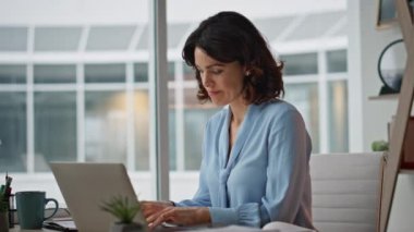 Modern ofis iç mekanında dizüstü bilgisayarı yazdıktan sonra kağıtları kontrol etmekle meşgul. Belgelerde motivasyonsuz profesyonel muhasebeci hatası var. Bilgisayar işyerinde çalışan iş kadını.